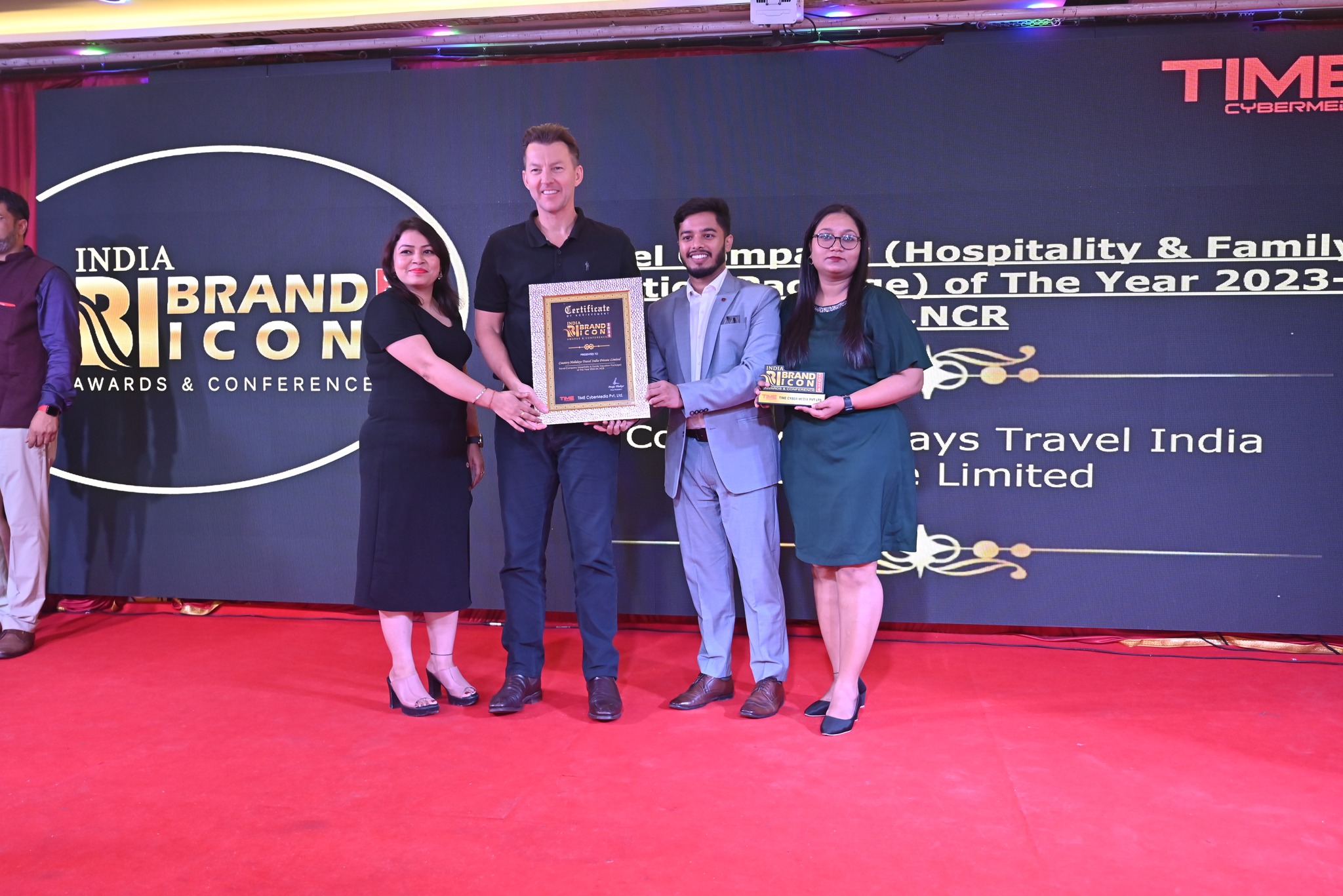Country Holidays Travel representatives receiving a certificate and trophy on the India Brand Icon stage