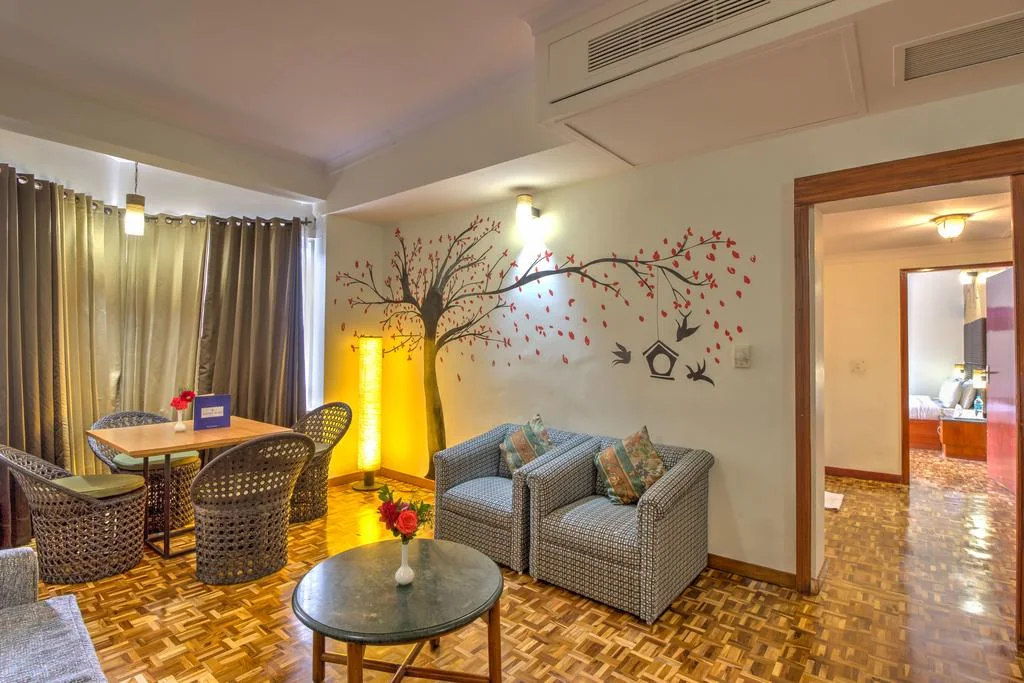 Guest-room seating area with a table, armchairs and sofa.