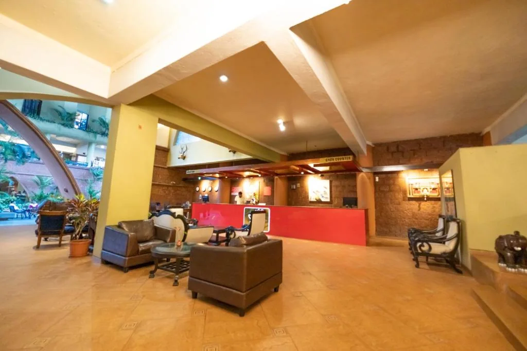 Hotel reception area with seating and a warm red reception desk.
