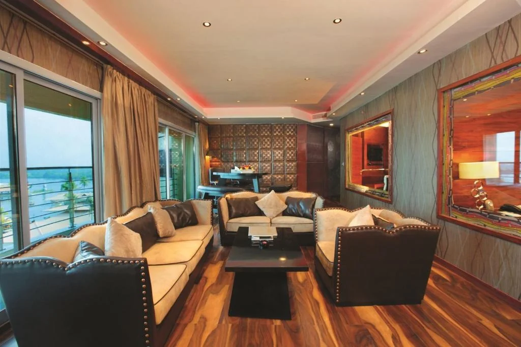 Suite lounge with upholstered seating, a desk and large windows.