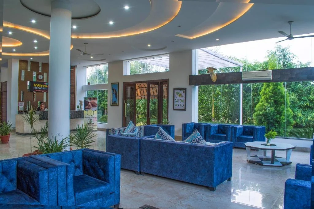 Blue lounge seating beside windows overlooking the garden.